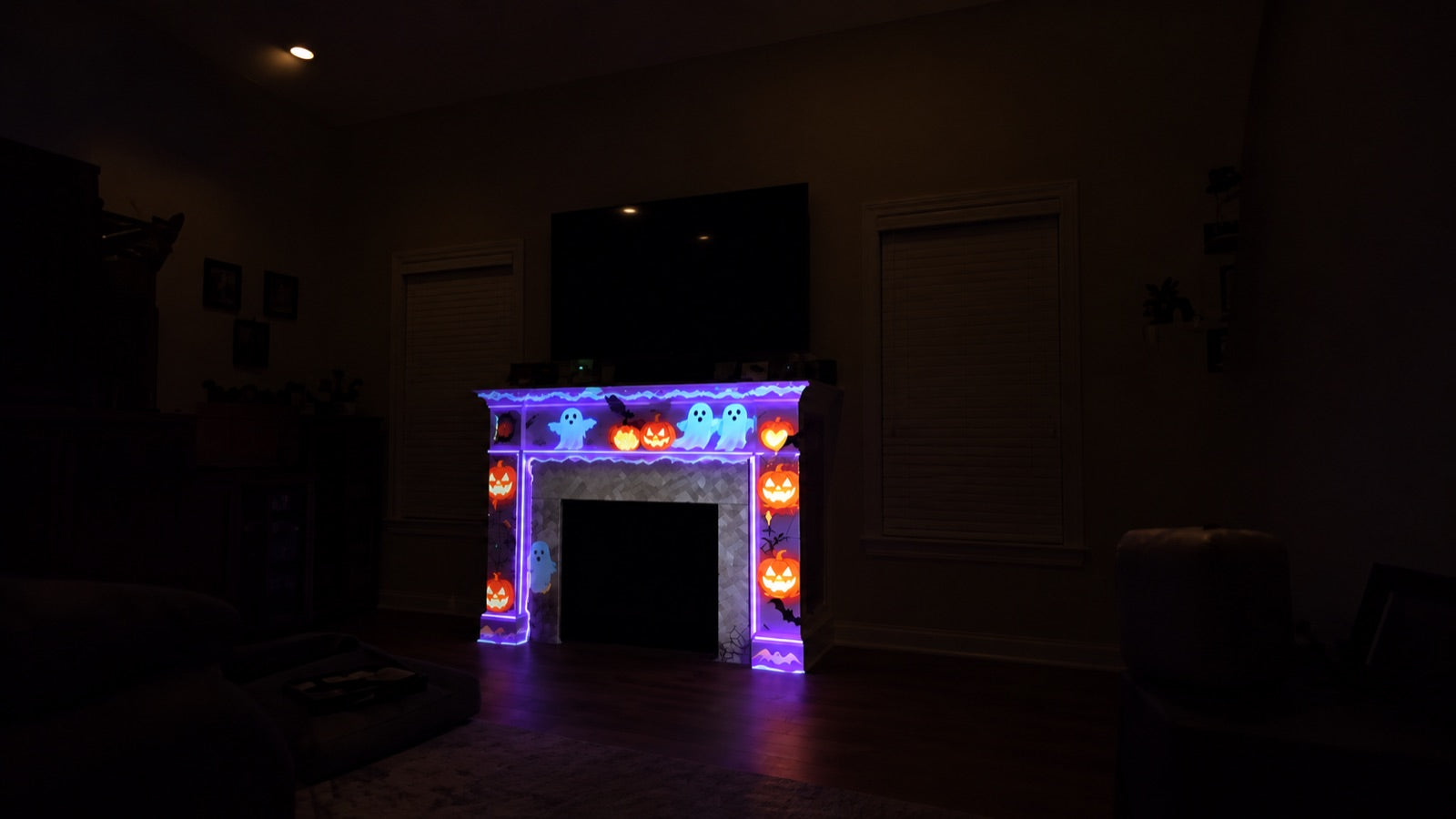 Halloween ghosts and jack-o-lanterns projection mapped across a fireplace mantel